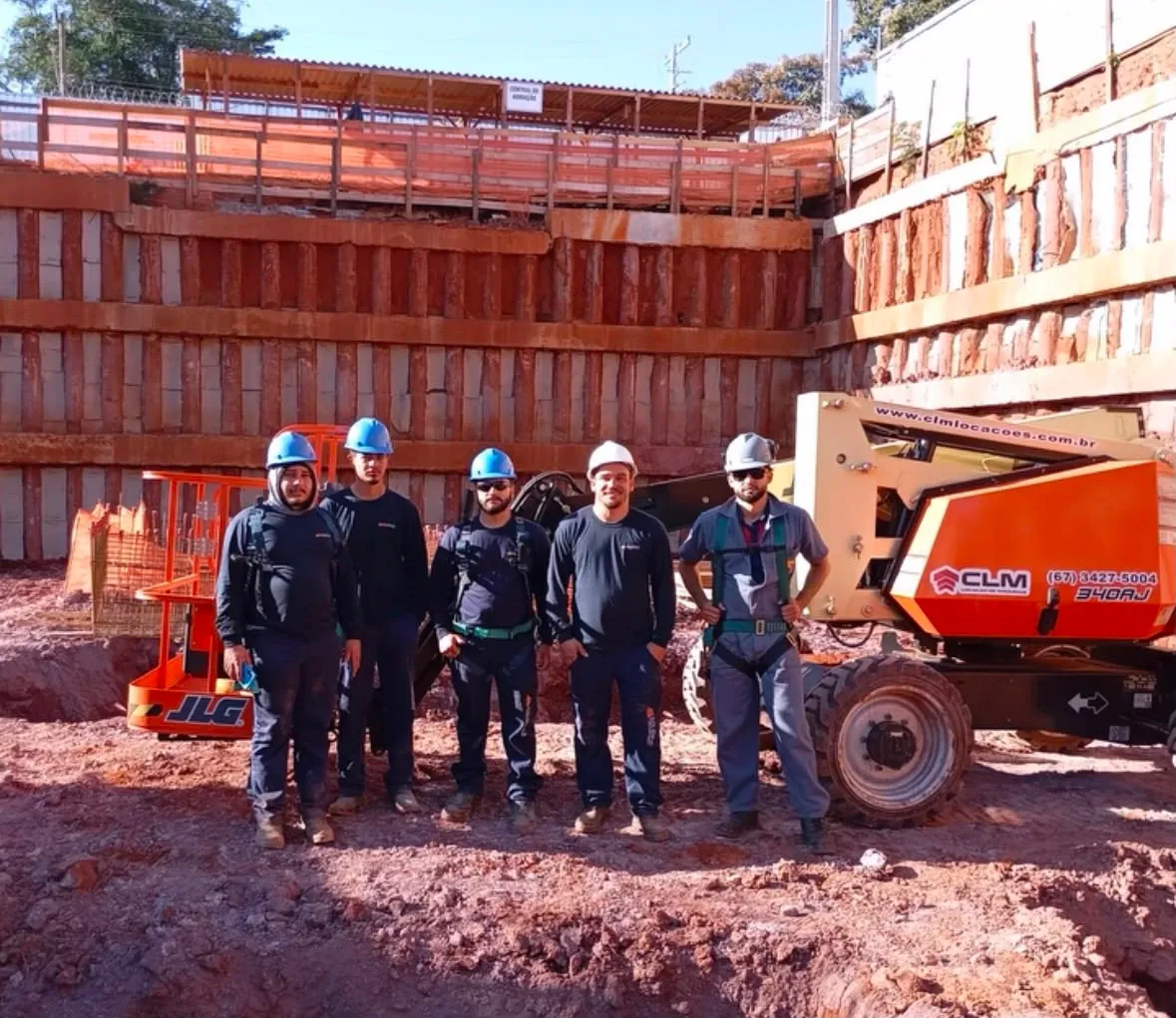 Turma de operadores em treinamento prático com plataforma JLG 340AJ em obra